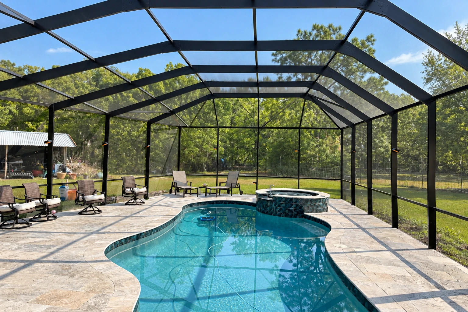 A black-framed screen enclosure covers a curved swimming pool, with a stone deck and reclining chairs along the sides.